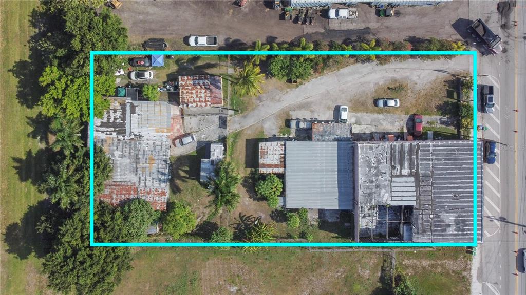 An aerial view shows a commercial property with multiple buildings, parking areas, and surrounding vegetation — 185 E MAIN STREET, PAHOKEE, FL
