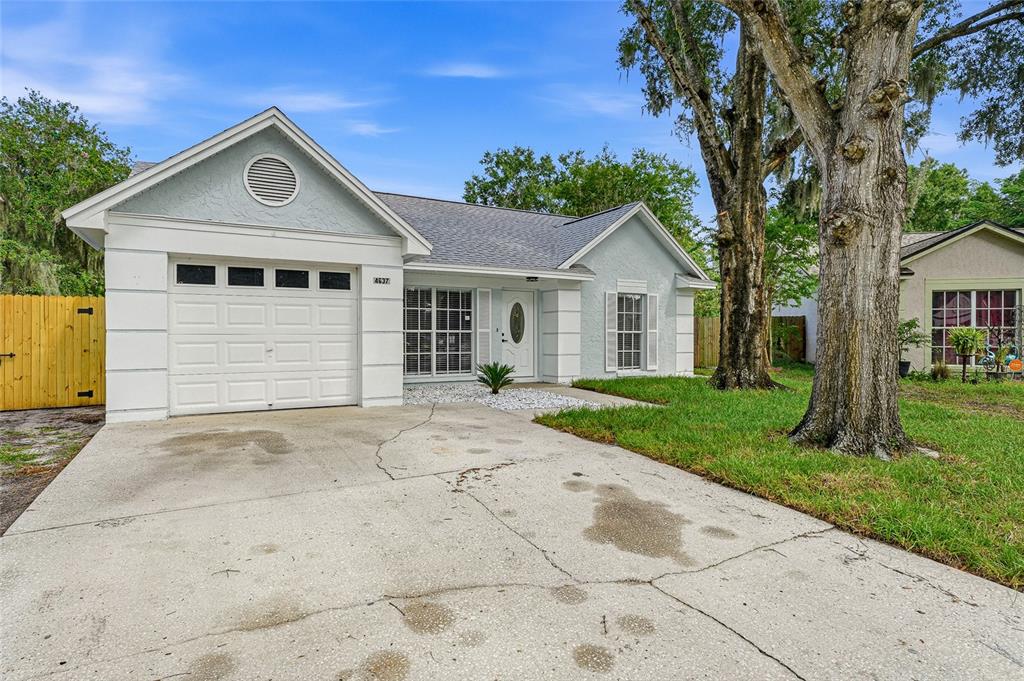 An aerial view shows a house with a wooden deck, swimming pool, and backyard waterfront — 4637 CABBAGE PALM DRIVE, VALRICO, FL