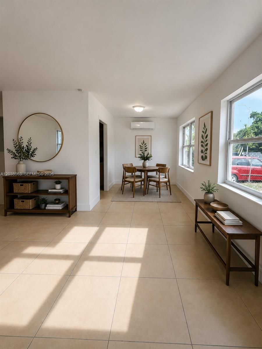 A dining area with a round table, chairs, and two wooden console tables on tile floors — 1857 NW 46th St # 1857, Miami FL 33142, MIAMI, FL