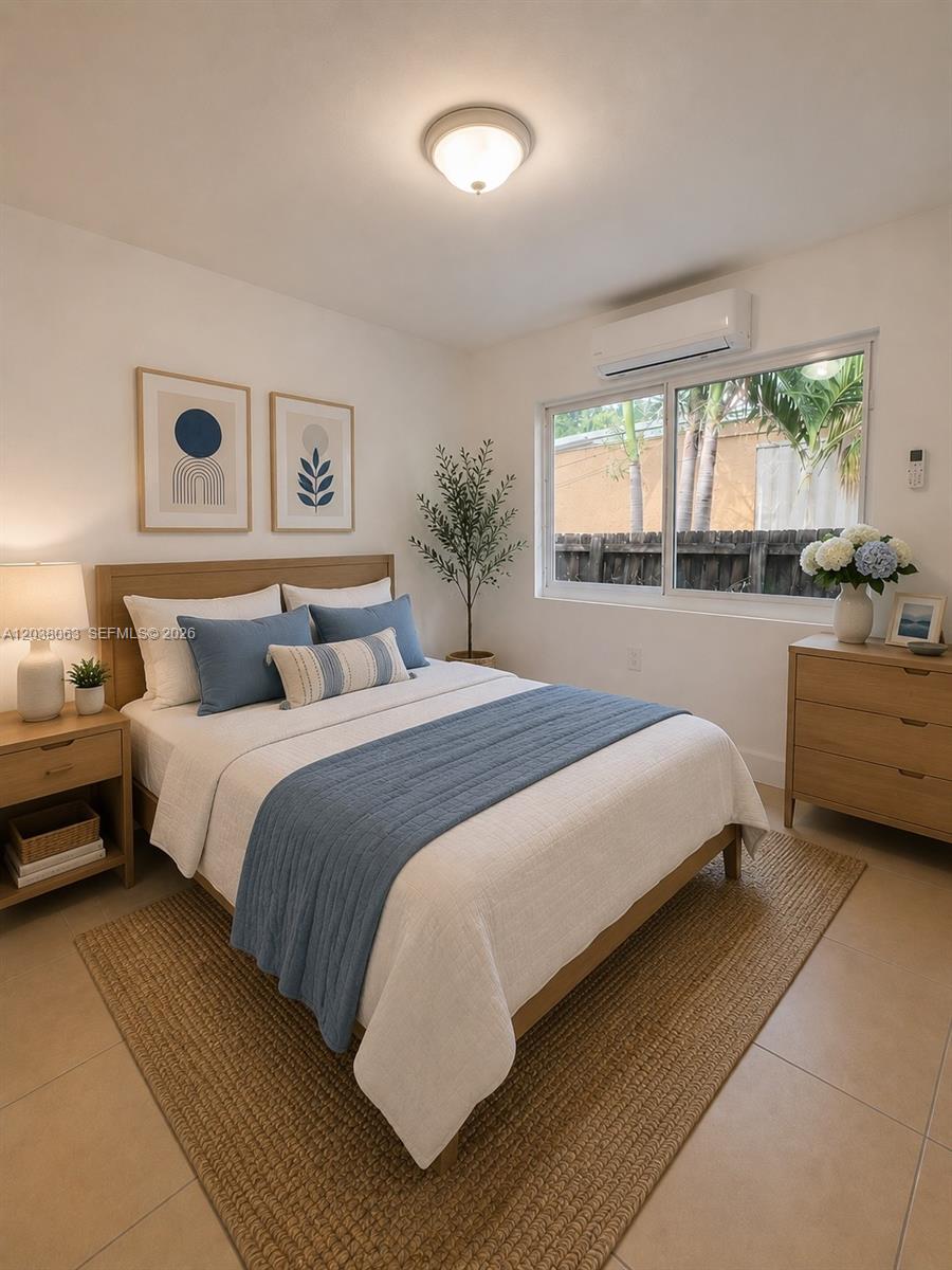 A bedroom features a bed with blue bedding, a wooden dresser, and a window view — 1857 NW 46th St # 1857, Miami FL 33142, MIAMI, FL