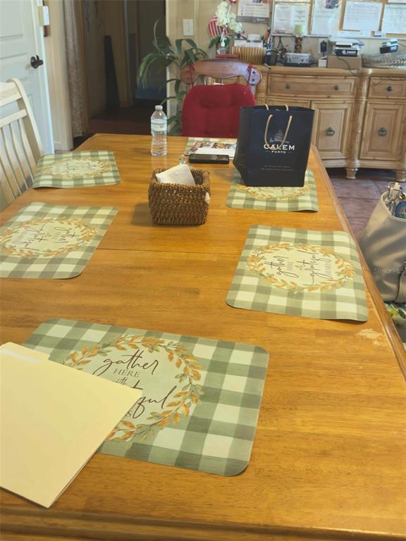 A wooden dining table is set with placemats in a room with a hutch — 1275 N BANANA RIVER DRIVE, MERRITT ISLAND, FL