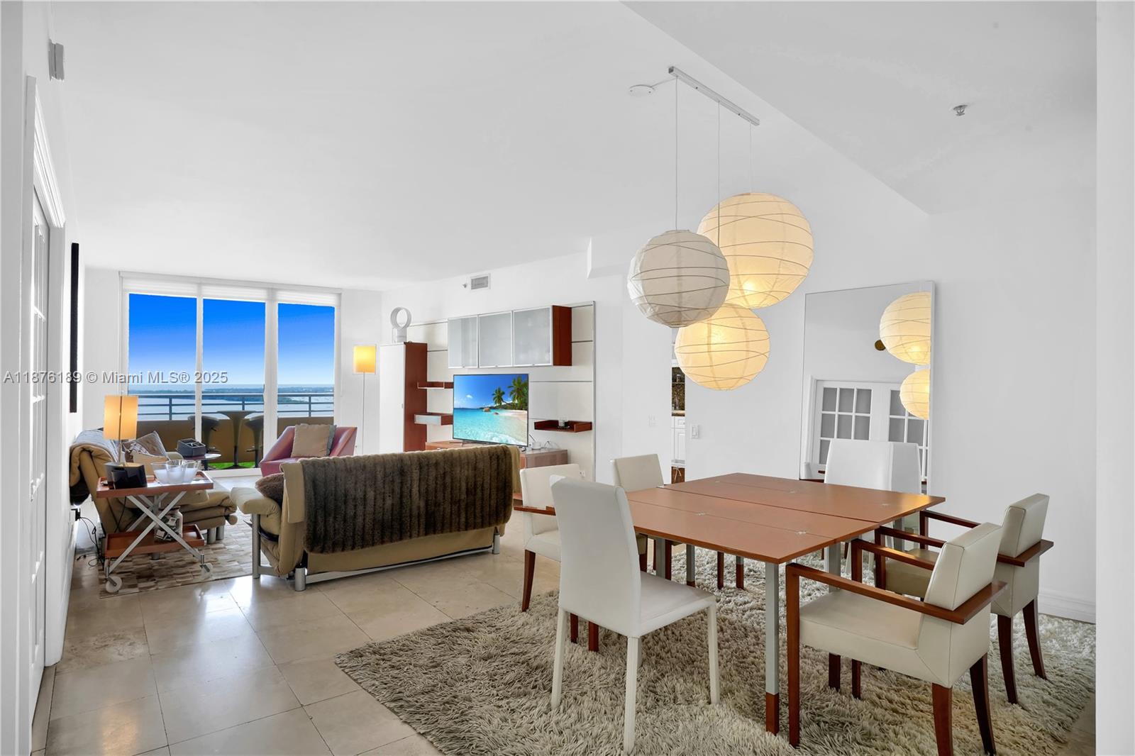 A living and dining area features white walls, tile floors, and a balcony with water views — 808 Brickell Key Dr # 2506, Miami FL 33131, MIAMI, FL
