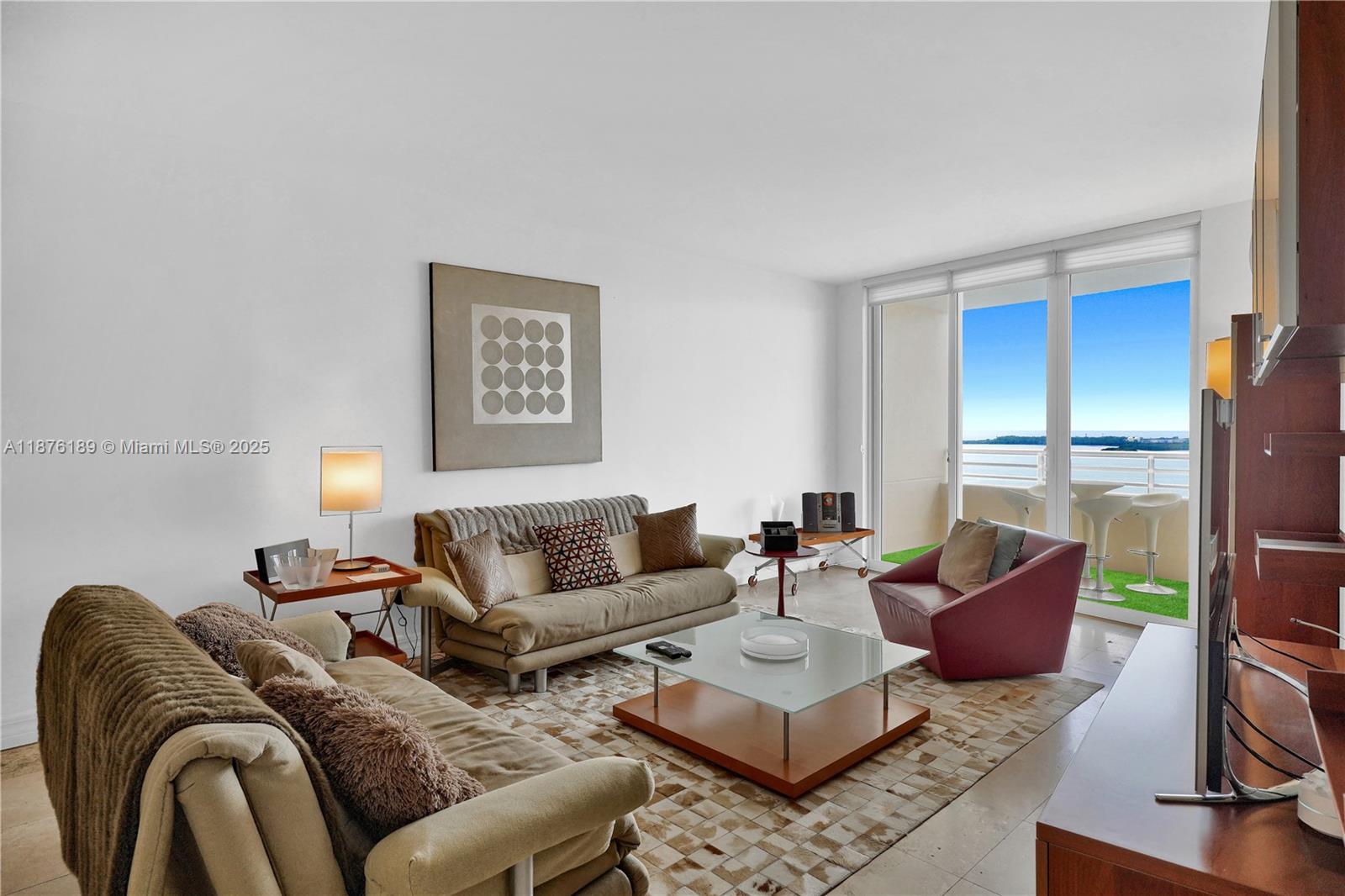 A living room features two sofas, a glass coffee table, and a balcony with water views — 808 Brickell Key Dr # 2506, Miami FL 33131, MIAMI, FL