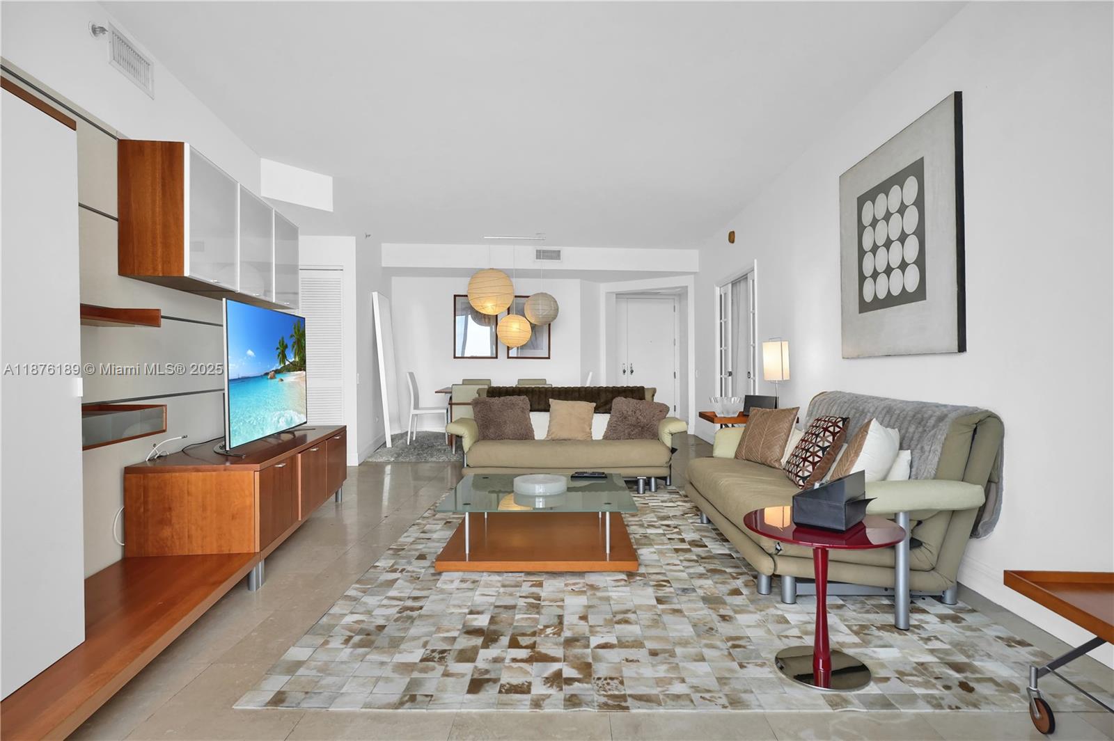 A living room features a television console, two sofas, a glass coffee table, and rugs — 808 Brickell Key Dr # 2506, Miami FL 33131, MIAMI, FL