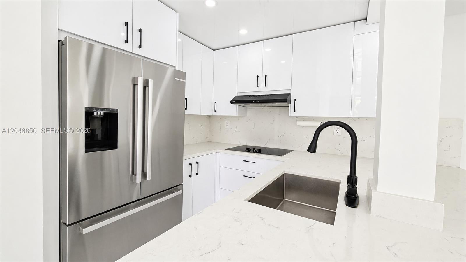 A modern kitchen features white cabinets, stainless steel appliances, and a black faucet — 9682 Fontainebleau Blvd # 203, Miami FL 33172, MIAMI, FL