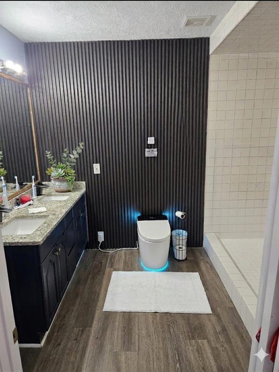 A bathroom features a dark slatted accent wall, a modern smart toilet, and a vanity — 7714 DELEUIL AVENUE, TAMPA, FL