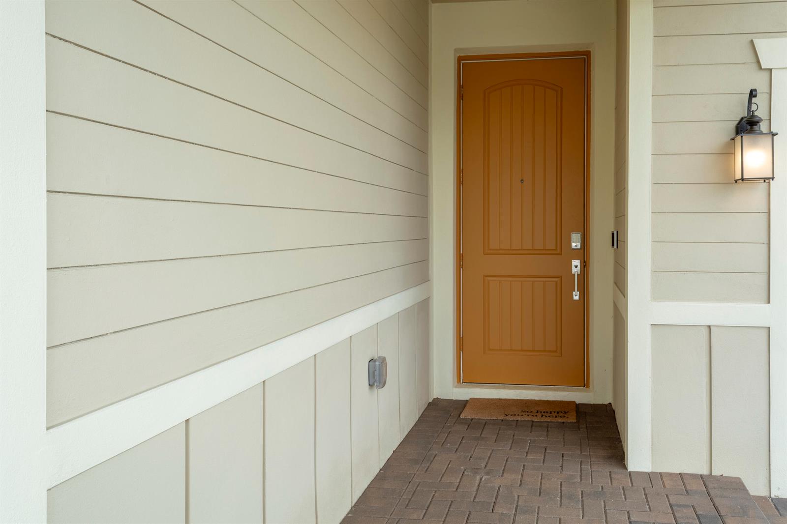 A tan front door with a brick porch and beige horizontal siding on the exterior — 560 Veridian Circle NW, Palm Bay FL 32907, PALM BAY, FL