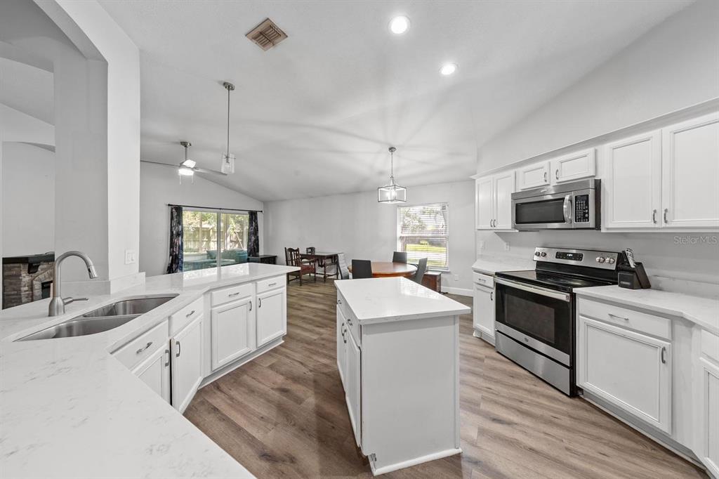 A kitchen with white cabinets, stainless steel appliances, and a central island — 1365 SHOOTINGSTAR LANE, ST JOHNS, FL