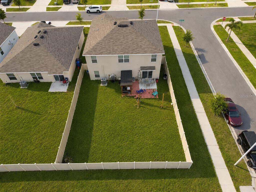 An aerial view shows a two-story house with a fenced backyard and a patio — 5480 LOGAN CAVE AVENUE, WIMAUMA, FL