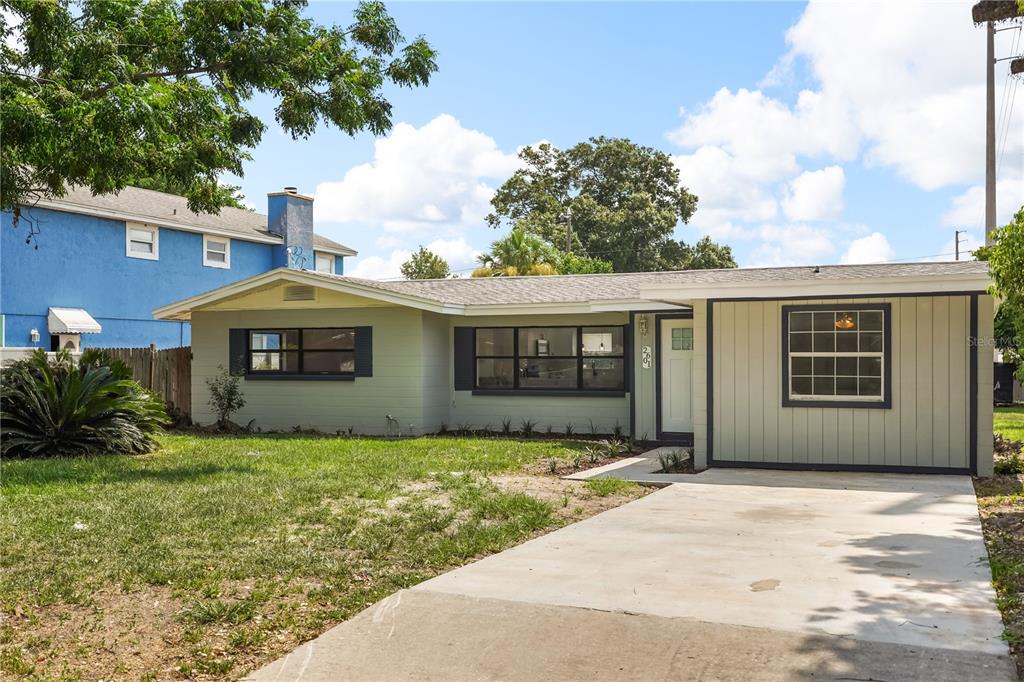 A single-story house with light green siding, a concrete driveway, and a small front lawn — 2601 HEALY DRIVE, ORLANDO, FL