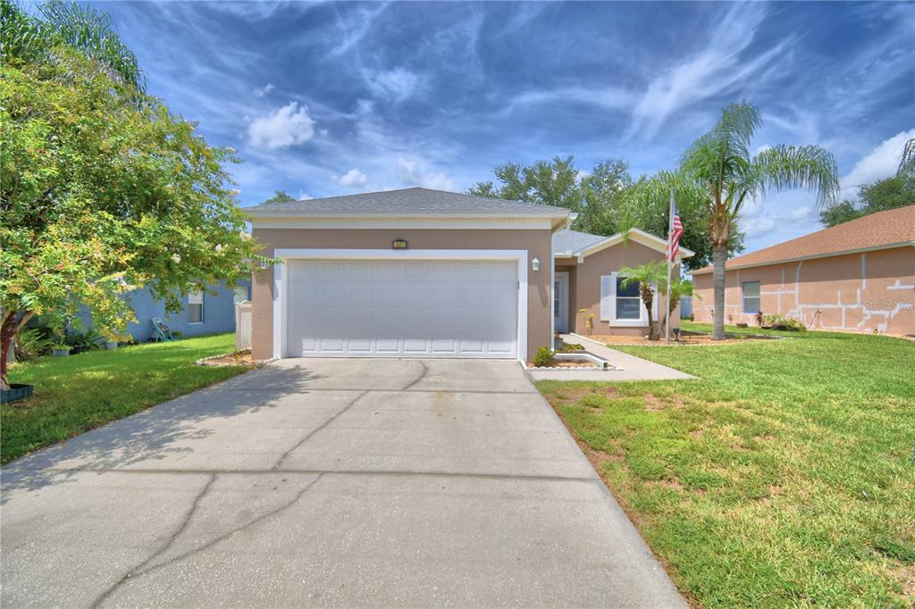 A single-story house with a two-car garage, a concrete driveway, and a front lawn — 5621 FOREST RIDGE DRIVE, WINTER HAVEN, FL