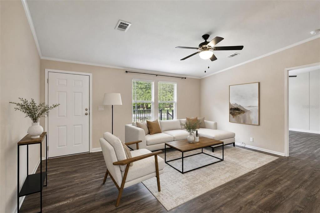 A living room features a white sectional sofa, an armchair, and a wooden coffee table — 136 CREEKWOOD RUN, LAKELAND, FL