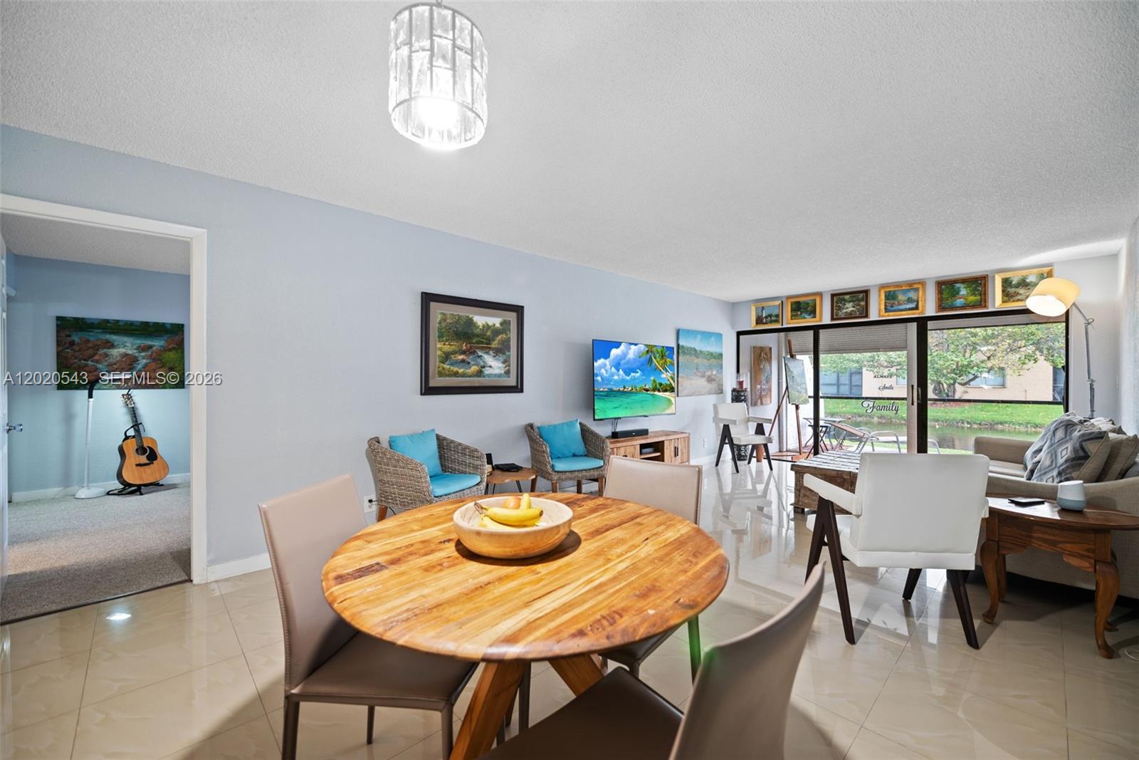 A dining area with a wooden table opens into a living room with tile floors — 200 Lakeview Dr # 113, Weston FL 33326, WESTON, FL
