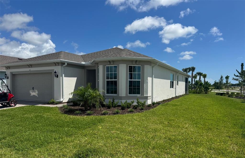 A single-story house with a beige stucco exterior, a two-car garage, and a bay window — 9118 SERENADE DRIVE, MELBOURNE, FL