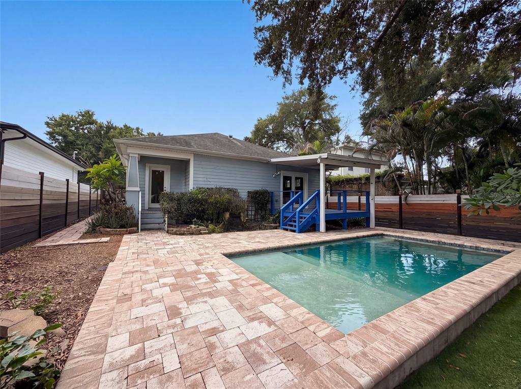A backyard features a swimming pool, a paved patio, and a blue wooden deck — 323 W LAMBRIGHT STREET, TAMPA, FL