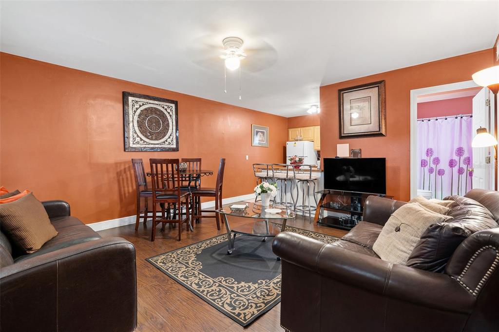 A living room with brown leather sofas, a dining set, and an open kitchen area — 2309 W CLUSTER AVENUE, TAMPA, FL