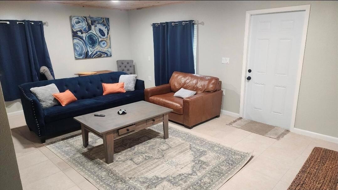 A living room features a blue sofa, brown leather chair, coffee table, and area rug — 618 Hunter Street, West Palm Beach FL 33405, WEST PALM BEACH, FL