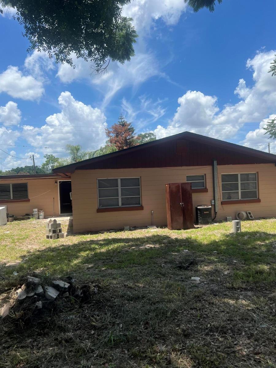 The exterior of a single-story house with tan siding, a brown roof, and several windows — 1858 4th Street SE, Winter Haven FL 33880, WINTER HAVEN, FL
