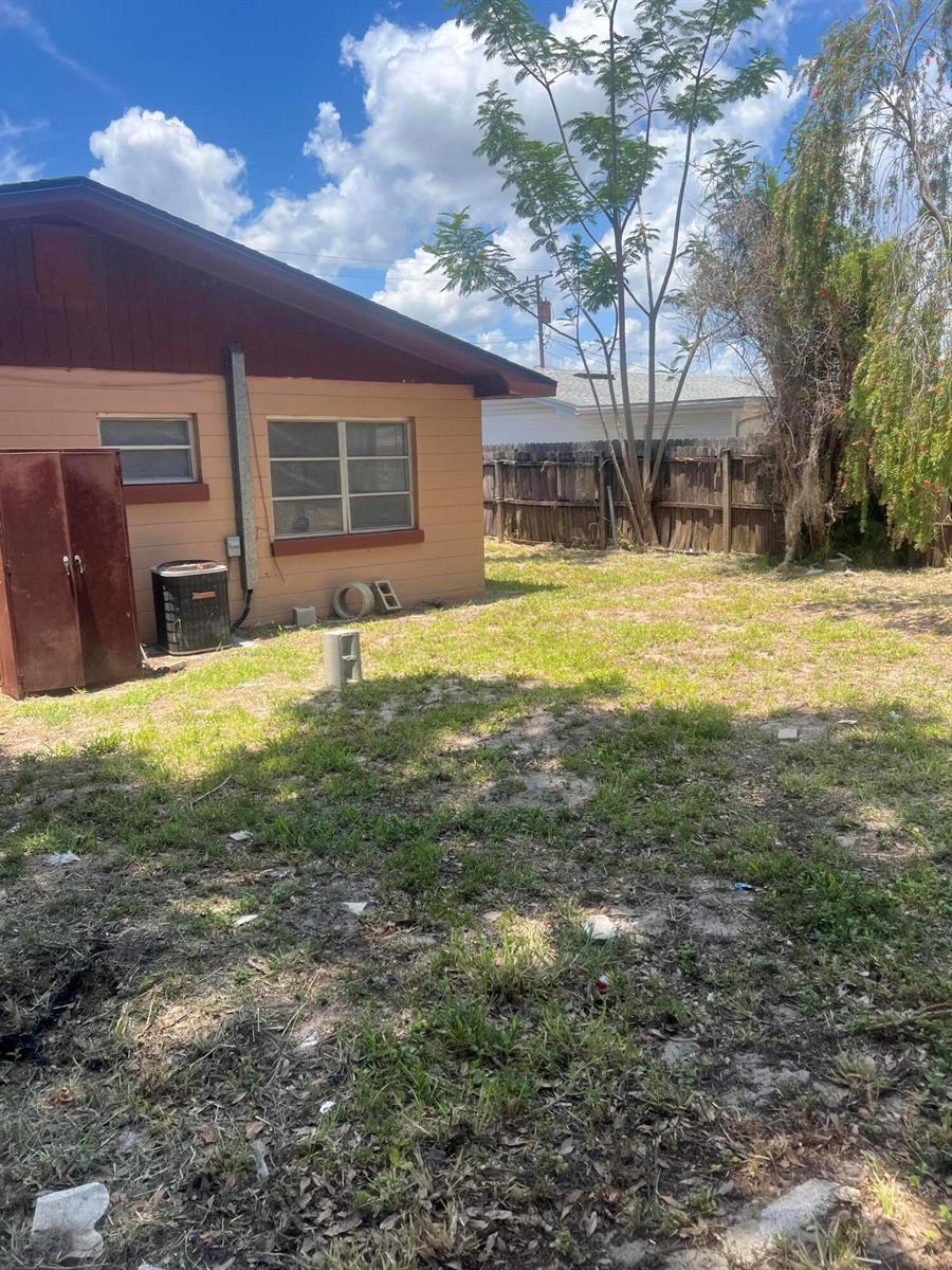 A view of the side of a house with a yard, fence, and trees — 1858 4th Street SE, Winter Haven FL 33880, WINTER HAVEN, FL