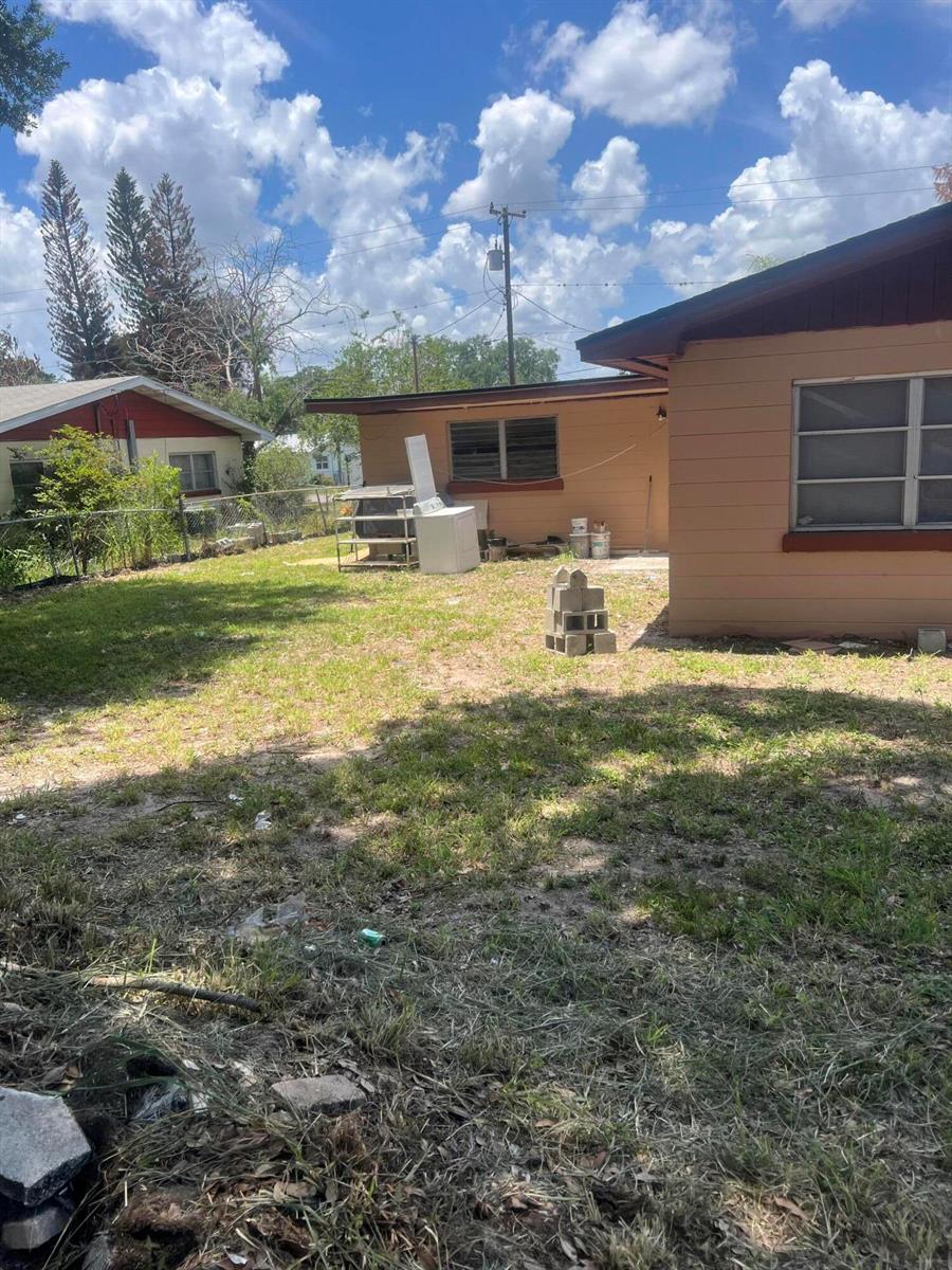 A backyard view shows a tan house exterior, a detached shed, and a washing machine — 1858 4th Street SE, Winter Haven FL 33880, WINTER HAVEN, FL
