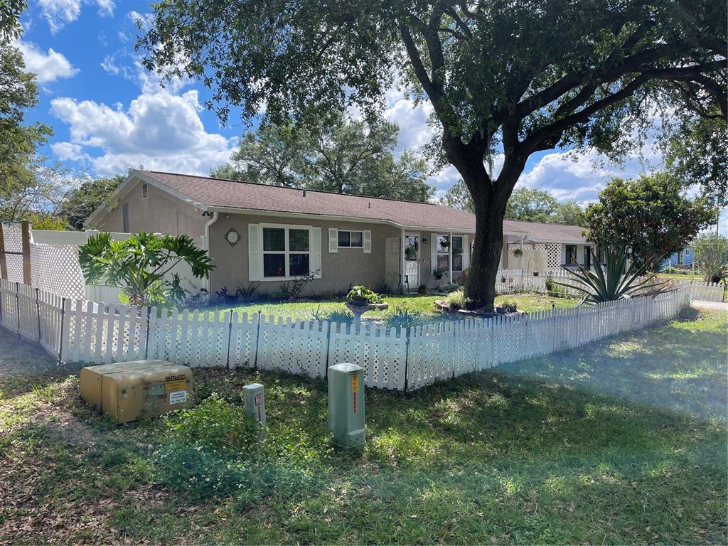 A single-story house with a white picket fence and a large tree in the front yard — 35 HICKORY TRACK WAY, OCALA, FL