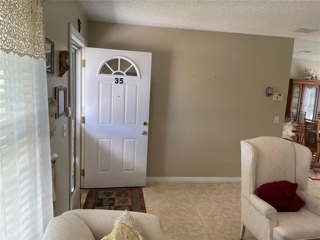 An entryway features a white front door with the number 35 and tiled flooring — 35 HICKORY TRACK WAY, OCALA, FL