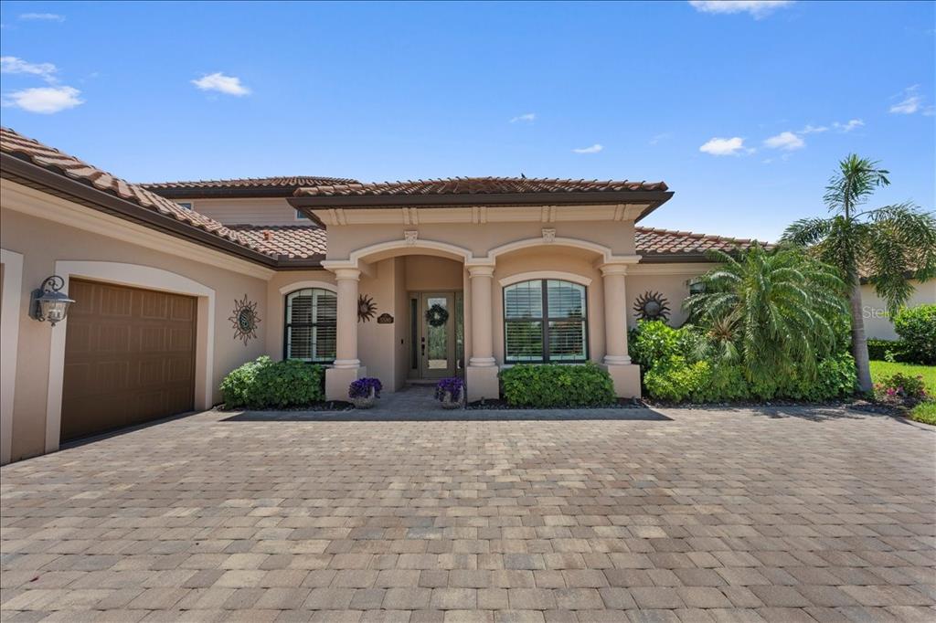 A single-story house with a paved driveway, a two-car garage, and a covered entryway — 5580 MULLIGAN WAY, LAKEWOOD RANCH, FL