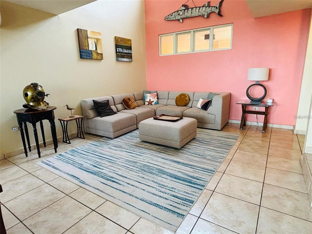 A living room features a beige sectional sofa, a matching ottoman, and a striped rug — 285 PALMAS INN DRIVE UNIT 8-302, HUMACAO, PR