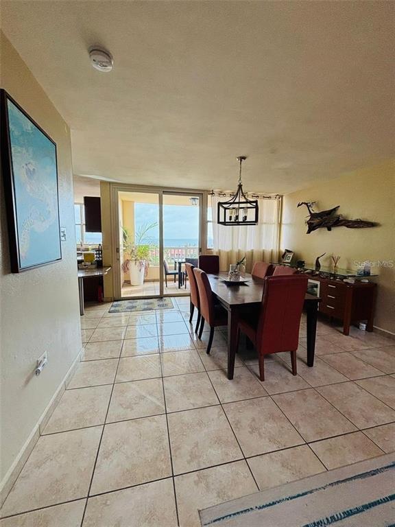 A dining area with a wooden table and chairs sits before a balcony overlooking the ocean — 285 PALMAS INN DRIVE UNIT 8-302, HUMACAO, PR
