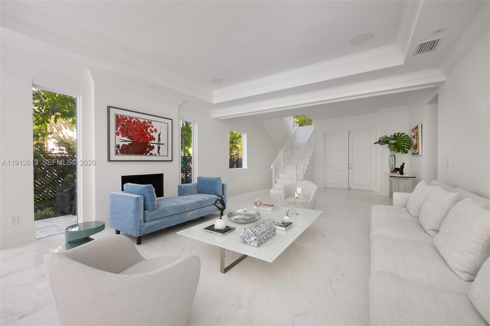 A bright living room features white marble floors, a blue velvet sofa, and a staircase — 2760 Brickell Ct # 2760, Miami FL 33129, MIAMI, FL
