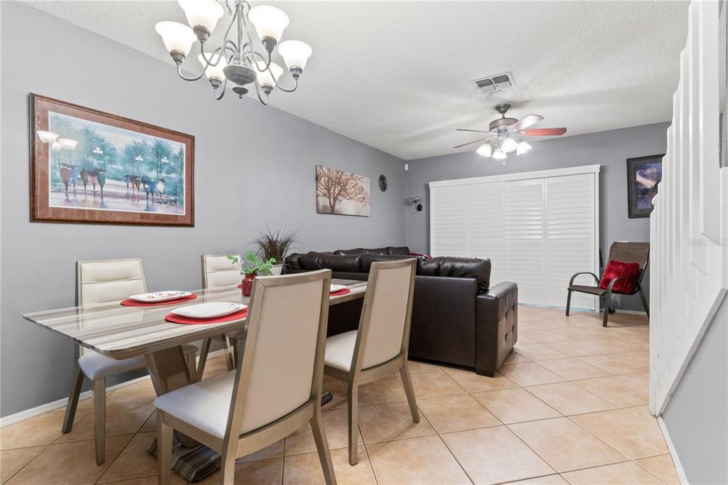 A dining area with a glass table and chairs sits in front of a living room — 8635 HUNTERS KEY CIRCLE, TAMPA, FL