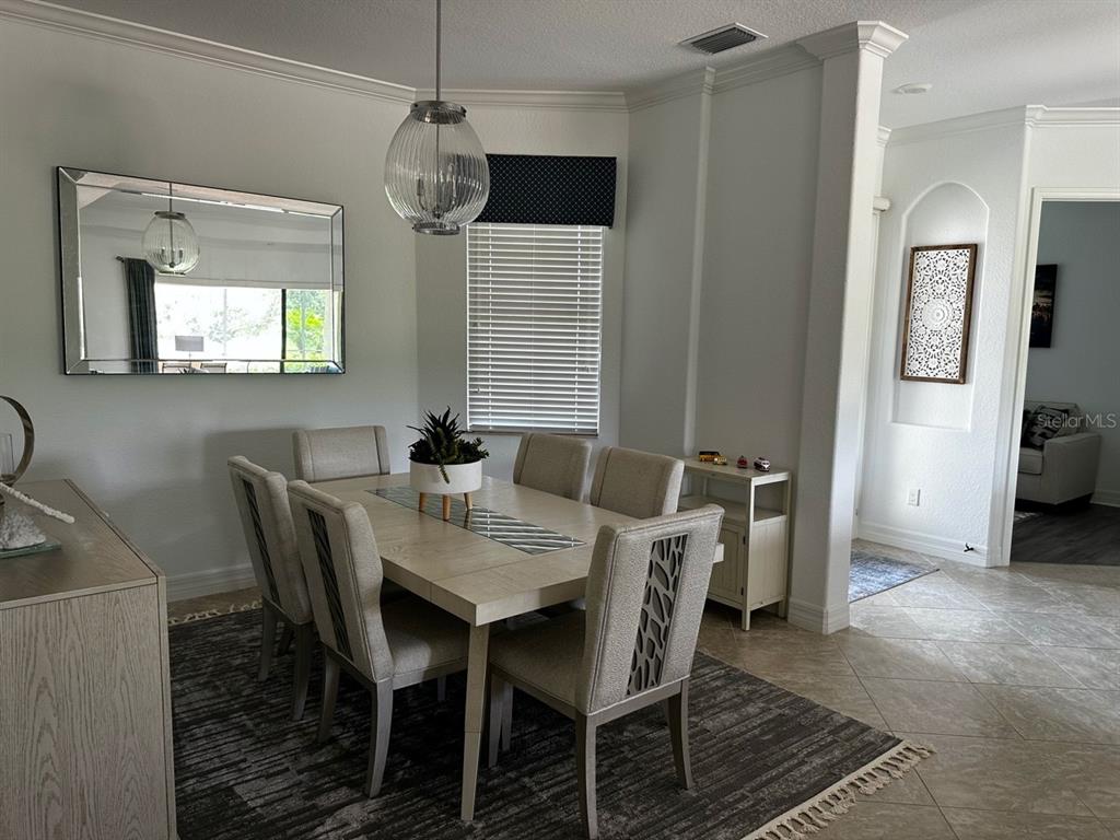 A dining room features a rectangular table with six chairs, a pendant light, and a mirror — 17025 POLO TRAIL, BRADENTON, FL