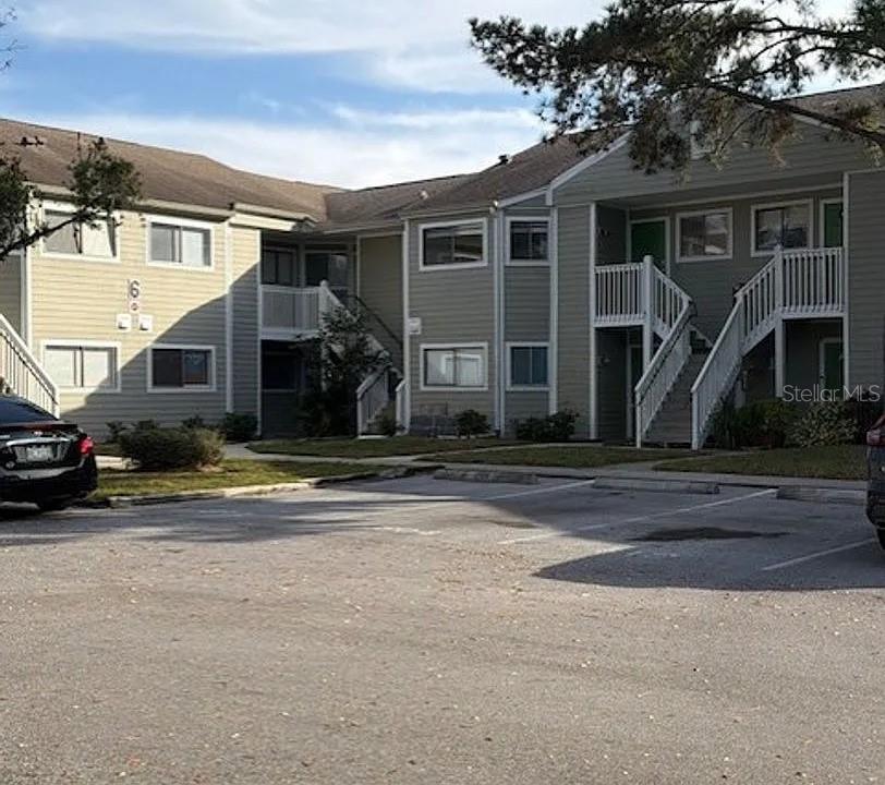 Exterior view of a multi-story apartment building with light siding and outdoor staircases — 7298 ULMERTON ROAD UNIT 616, LARGO, FL