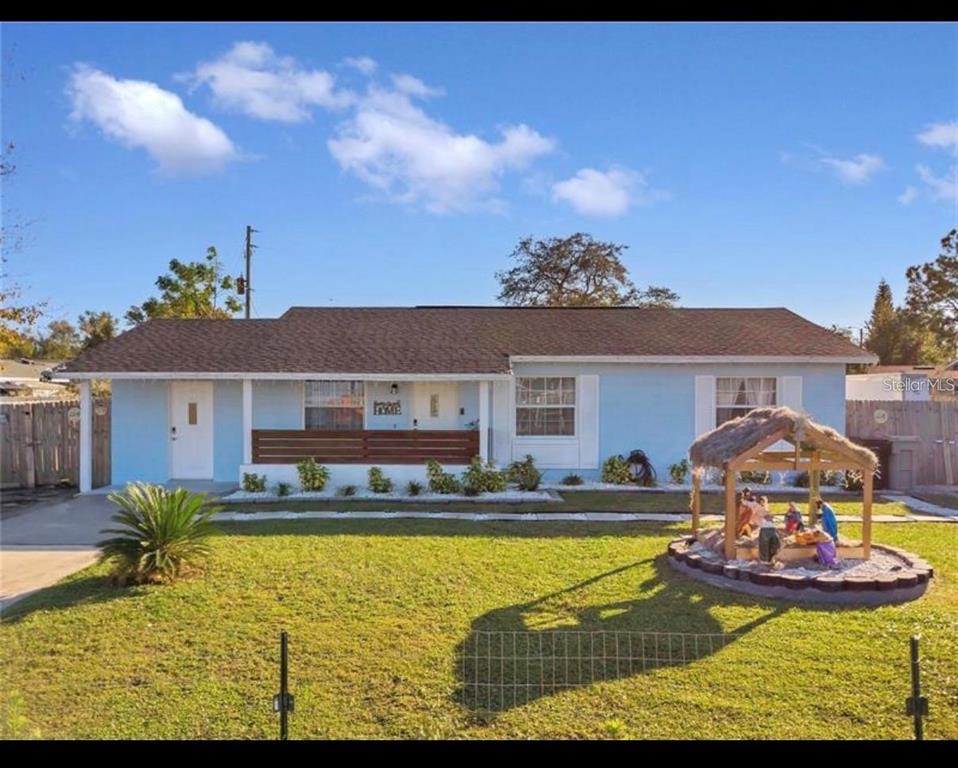 A light blue single-story house features a front porch, a lawn, and a nativity scene — 314 W GROSSENBACHER DRIVE, APOPKA, FL