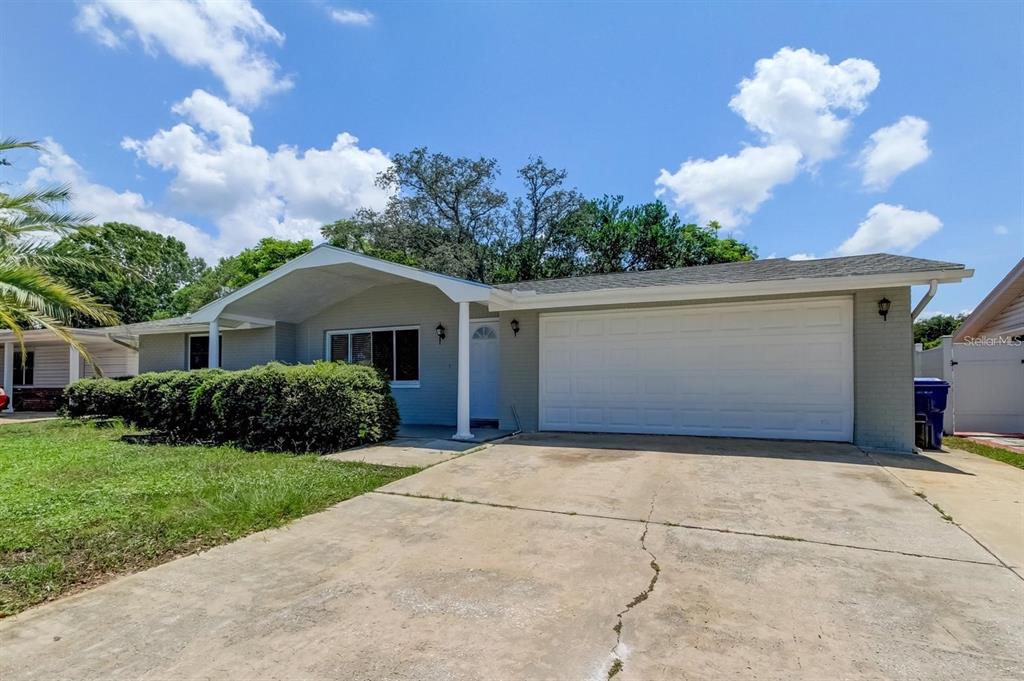 A single-story house with a gray exterior, a two-car garage, and a concrete driveway — 7144 FAIRFAX DRIVE, PORT RICHEY, FL