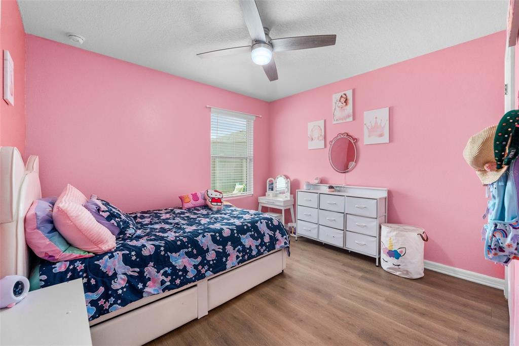 A bedroom with pink walls, a unicorn-themed bed, a white dresser, and a ceiling fan — 16467 NW 192ND TERRACE, HIGH SPRINGS, FL
