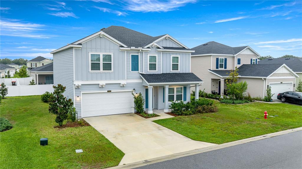 A two-story light blue house with a two-car garage and a front porch — 3980 NE 34TH AVENUE, OCALA, FL