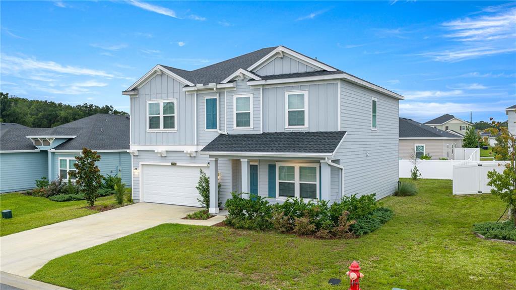 A two-story light blue house with a two-car garage and a front porch — 3980 NE 34TH AVENUE, OCALA, FL