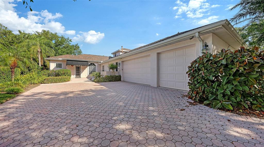 A paved driveway leads to a house with a two-car garage and a front entrance — 7025 N SERENOA DRIVE, SARASOTA, FL