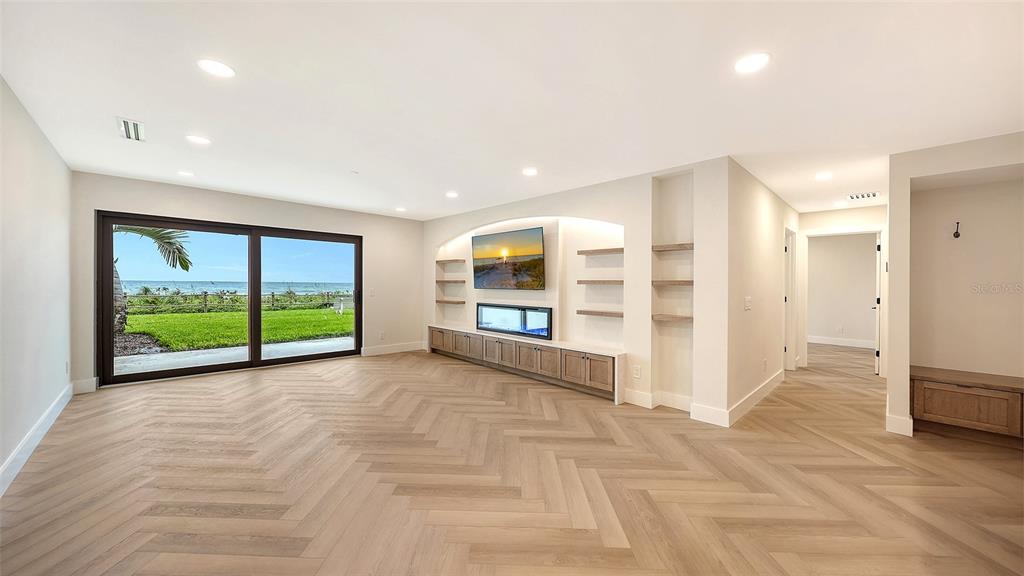 A living room features a beige sofa, two armchairs, a wood coffee table, and ocean views — 2089 GULF OF MEXICO DRIVE UNIT G1-104, LONGBOAT KEY, FL