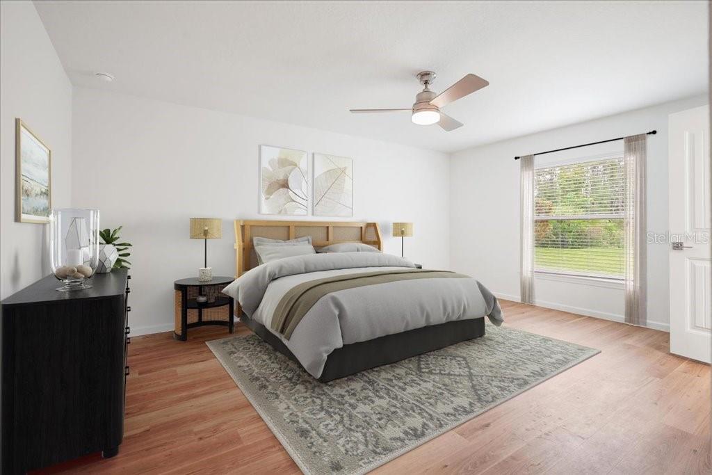 A bedroom features a bed with a wooden headboard, a ceiling fan, and a window — 24 WOODSIDE DRIVE, PALM COAST, FL