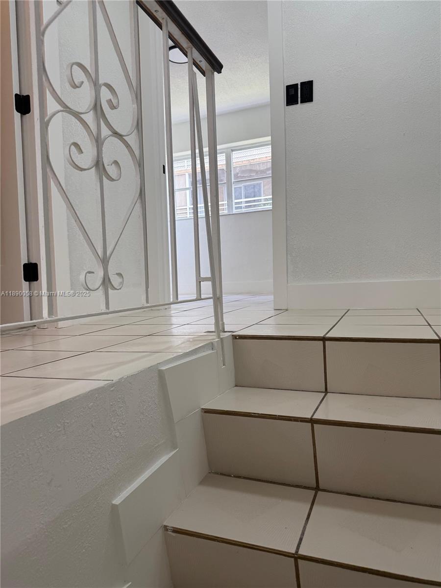 A set of tiled stairs leads up to a landing with a decorative metal railing — 6625 W 4th Ave # 204, Hialeah FL 33012, HIALEAH, FL