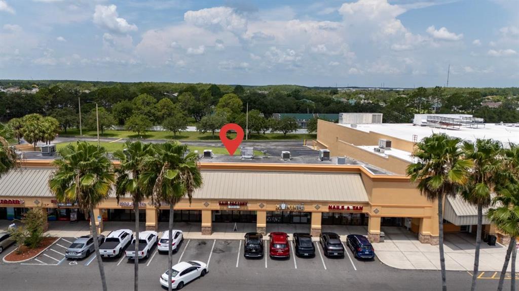 An aerial view shows a strip mall with a red location pin on the roof — 13880 LANDSTAR BOULEVARD, ORLANDO, FL