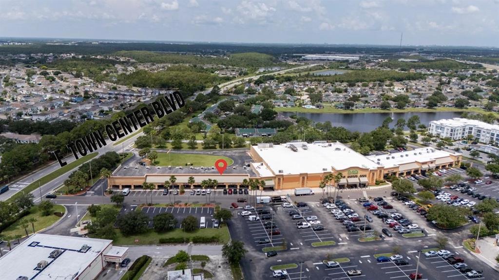 An aerial view shows a commercial shopping center with a large parking lot — 13880 LANDSTAR BOULEVARD, ORLANDO, FL
