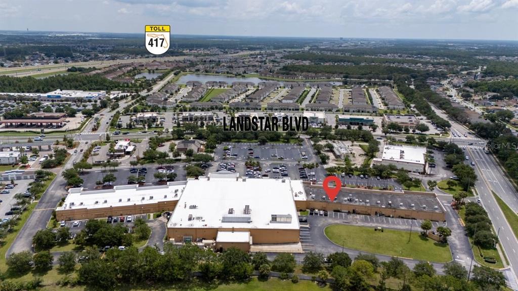 An aerial view shows a large commercial building with a red location pin — 13880 LANDSTAR BOULEVARD, ORLANDO, FL