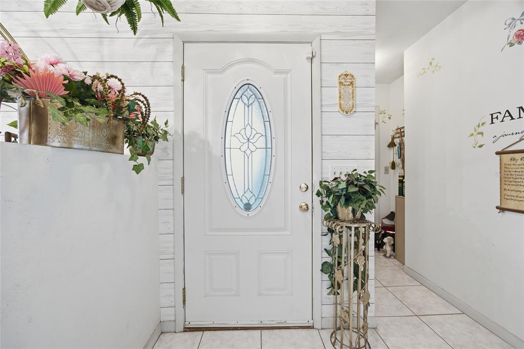 An entryway features a white front door with an oval glass insert and shiplap walls — 549 SILVER COURSE RUN, OCALA, FL