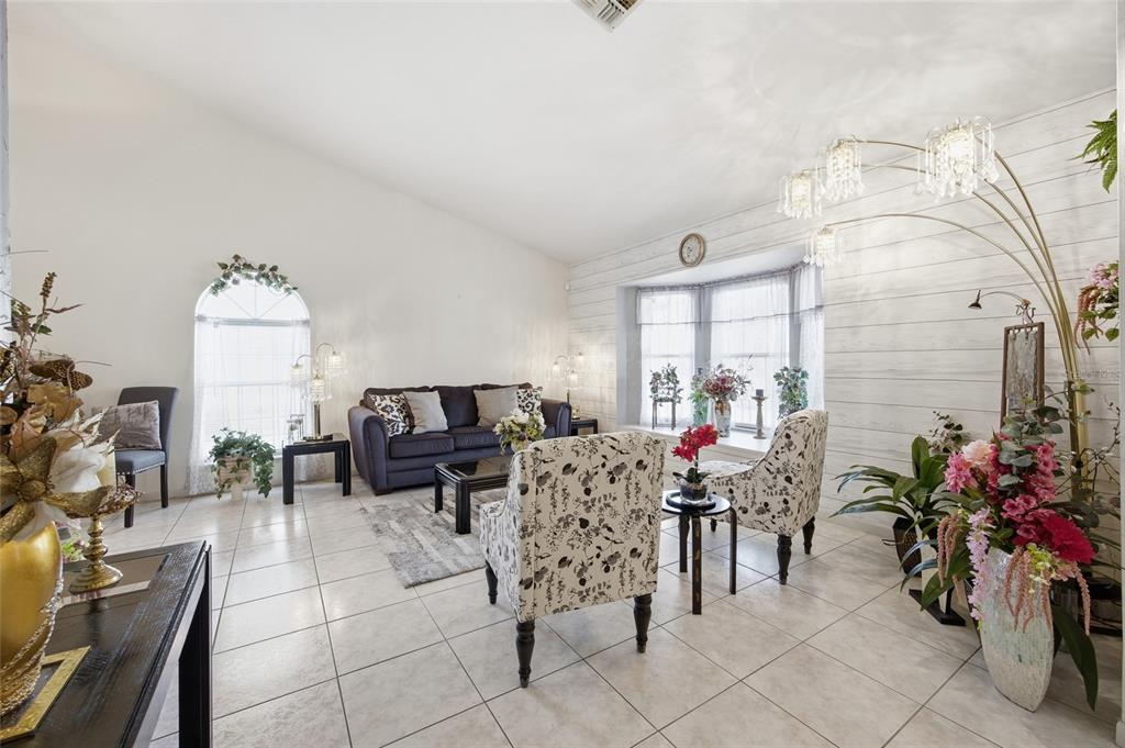 A living room features tile floors, a bay window, and a large arched window — 549 SILVER COURSE RUN, OCALA, FL