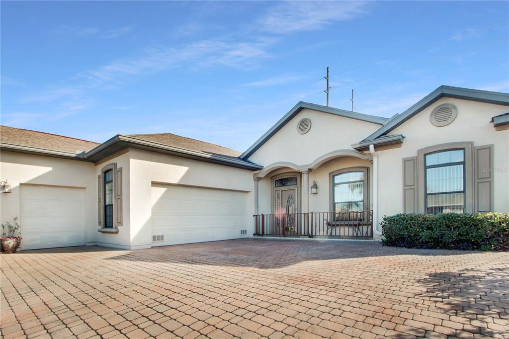 A single-story house with a paved driveway, a three-car garage, and a covered front entryway — 17996 SE 115TH CIRCLE, SUMMERFIELD, FL