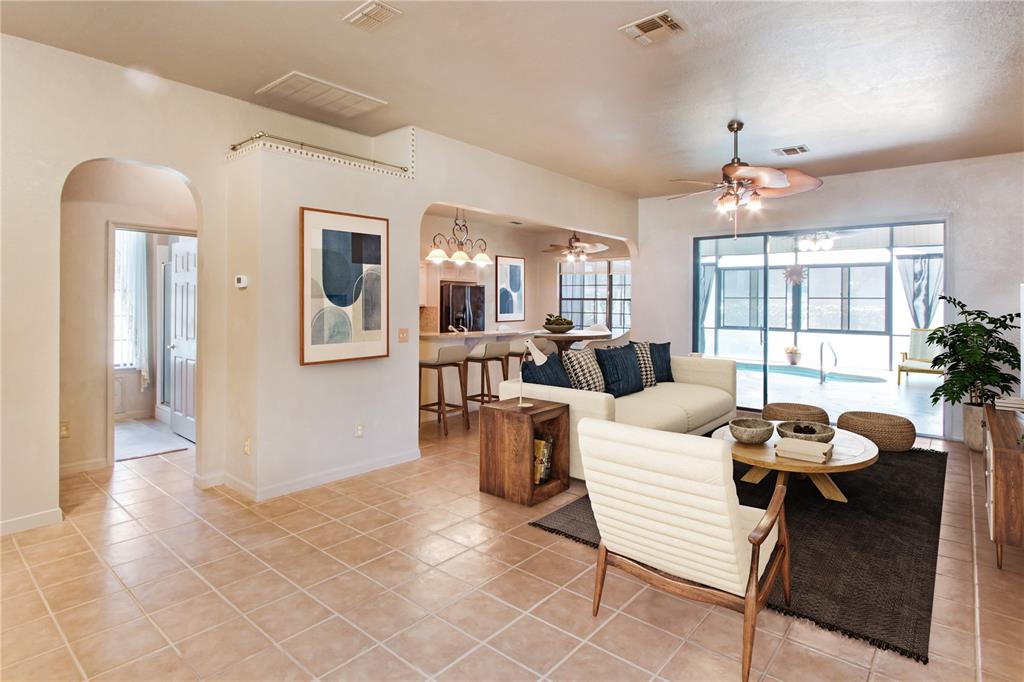 A living room with tile floors, a white sofa, and a view of a pool — 17996 SE 115TH CIRCLE, SUMMERFIELD, FL