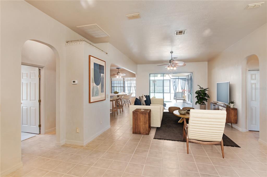 An open-concept living room and dining area with tile flooring and a view of a lanai — 17996 SE 115TH CIRCLE, SUMMERFIELD, FL
